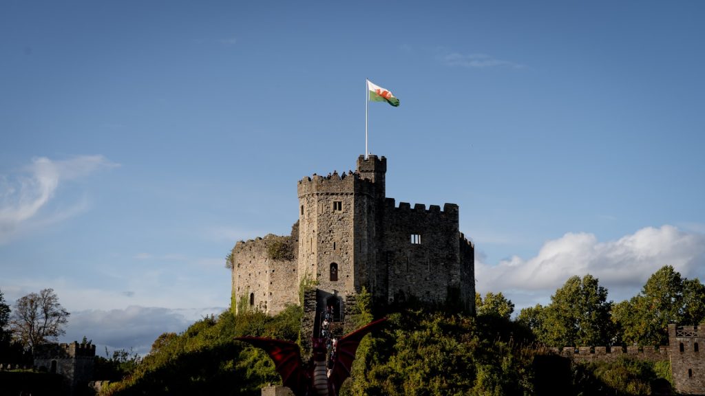The Norman keep at Cardiff Castle under a blue sky, Welsh flag flying