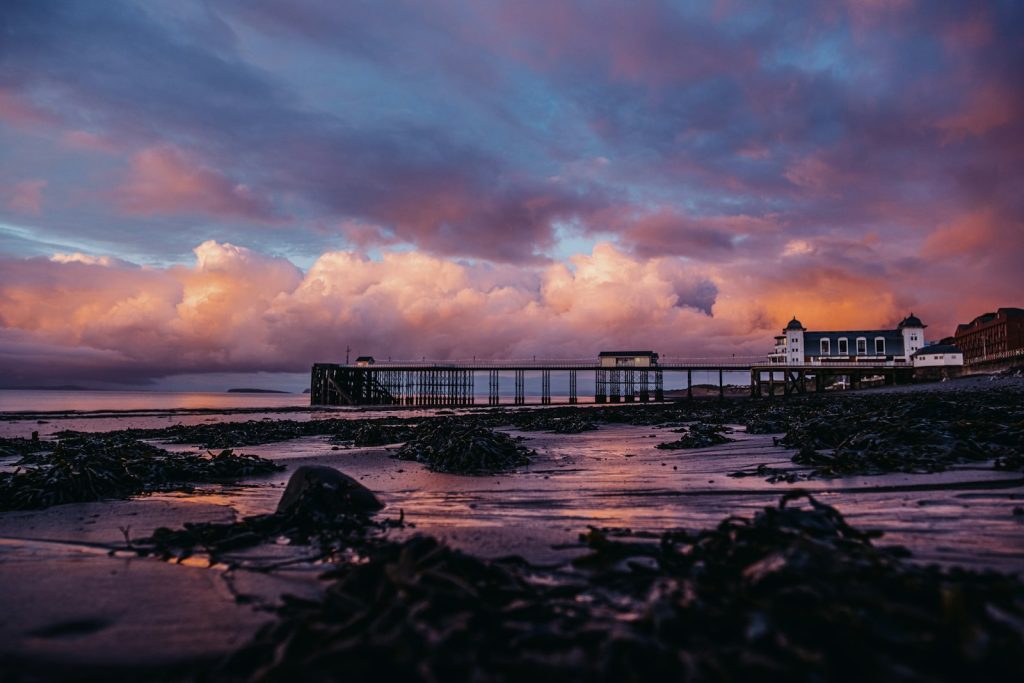 Sunset over Penarth Pier and the rocky foreshore